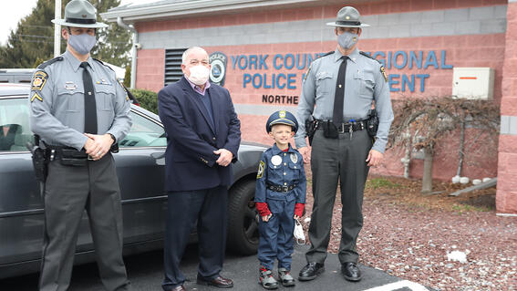 Landen stands outside the police department with his fellow officers.