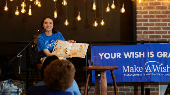 Wish kid Amelia on stage at her book launch party
