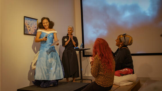 Katina in a long soft fabric dress, designed with clouds. 