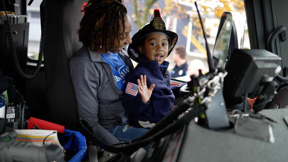 Jayce in the firetruck on his mom in the driver's seat