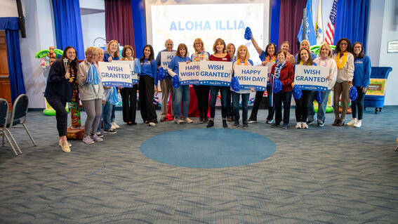Image shows a group of volunteers posing with signs