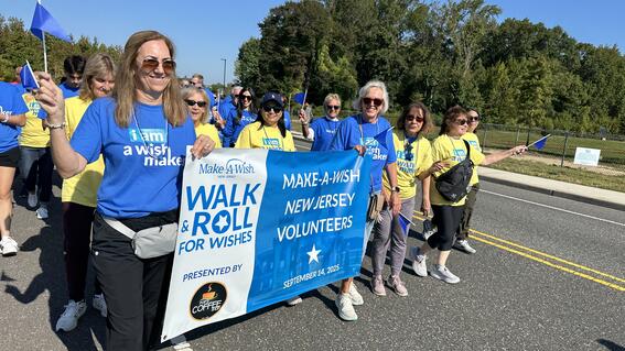 Image shows a group of volunteers walking holding a banner