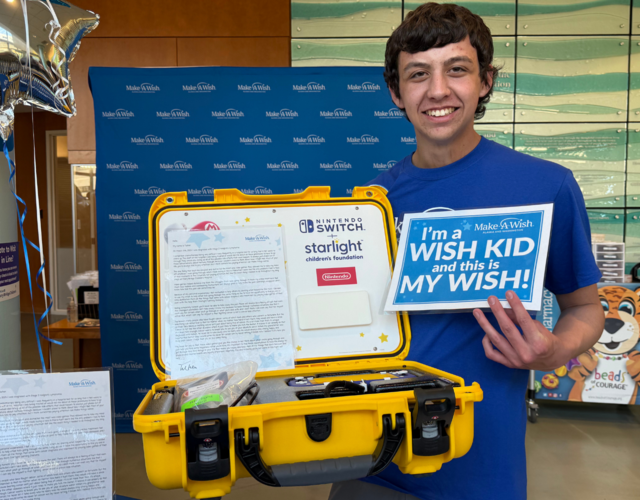 Tucker smiling with the donated gaming consoles