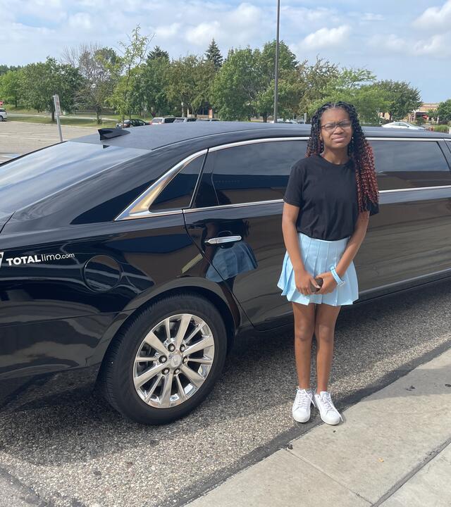 Carrington in front of a limo on her wish day. 