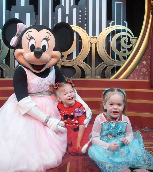 Hazelle in a blue dress with Minnie Mouse at Disney World