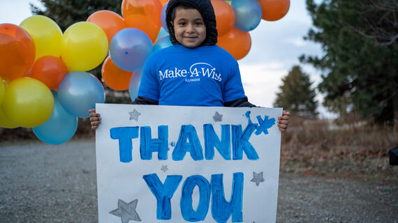 Wish child Sebastian holding up a thank you sign