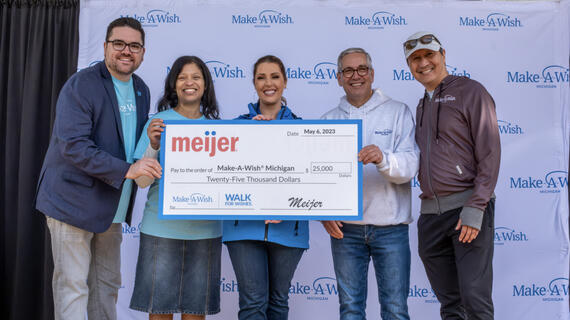 group of adults on stage holding giant check