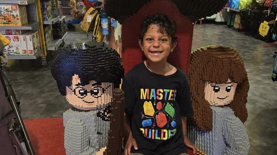 A boy standing in front of harry potter legos