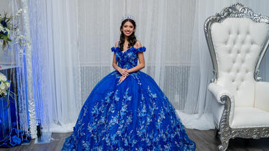 Wish kid Alexis standing in her blue quinceañera dress smiling