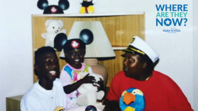 Three people sitting together, a child and an adult are hugging