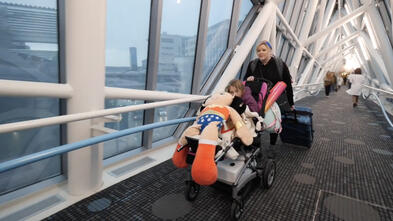 Mom and wish child entering hospital across pedestrian bridge