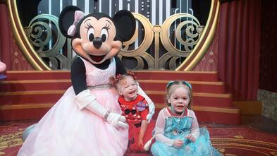 Hazelle in a blue dress with Minnie Mouse at Disney World