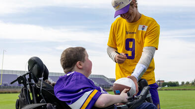Nash receiving a football from QB JJ McCarthy
