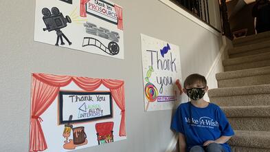 Miles smiling with thank you posters