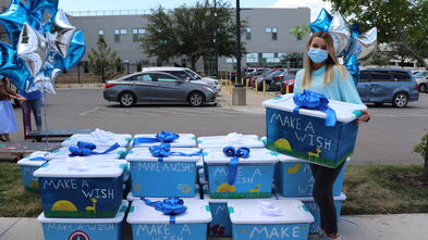 Lauren standing next to her boxes full of comfort items for the kids at Dell Children's.