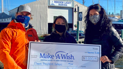 The owners of Borden Light Marina hold a check for $11,000.