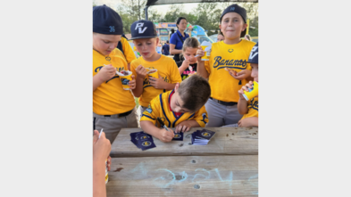 Dominic signing his baseball cards