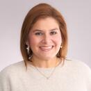 Jennifer Combs headshot on neutral background, woman smiling 