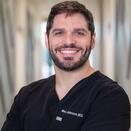 Wes Johnson headshot, man wearing black scrubs smiling 