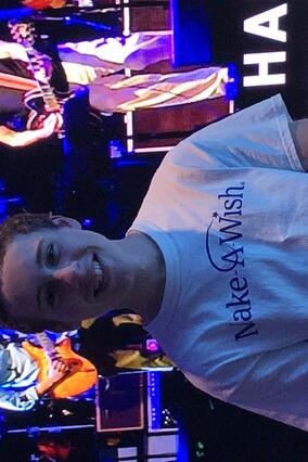 Zach posing in front of the stage at the concert