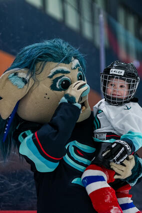 Caleb smiling with Buoy (Kraken Mascot)