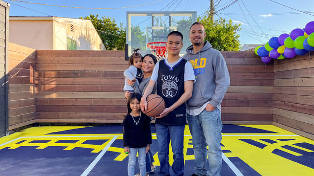 Wish Kid Isaiah with his family on his new backyard basketball court