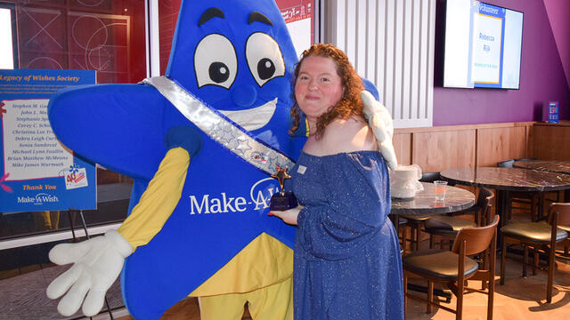 Rebecca holding her volunteer trophy next to Sparkle